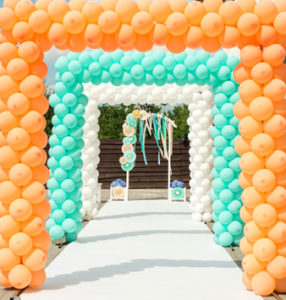 orange, sea green and white balloon arches