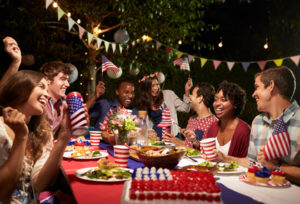 big 4th of july party with lots of people at picnic table