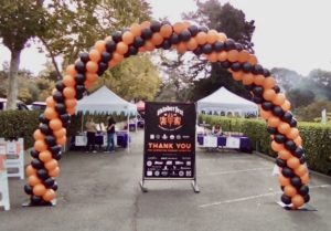 black and orange balloon arch outdoors