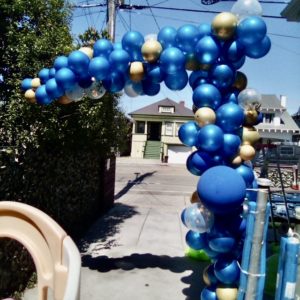 blue and gold balloon half arch at home outdoors